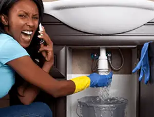 Emergency plumbing repair for a leaking sink drain under a bathroom vanity in Miami, FL