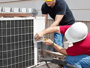HVAC technicians repairing an outdoor AC unit on a rooftop in Miami, FL