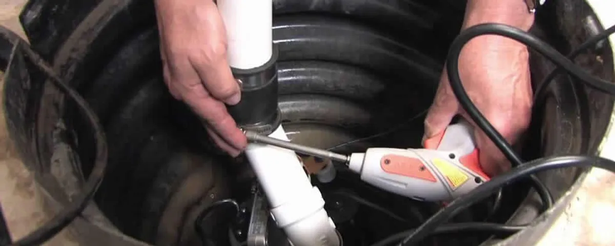 Sump pump installation technician connecting PVC discharge piping in Miami, FL